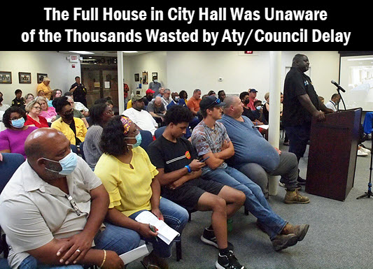 Photo of a full house in City Hall. The caption reads: the full house in city hall was unaware of the thousands wasted by attorney/council delay 