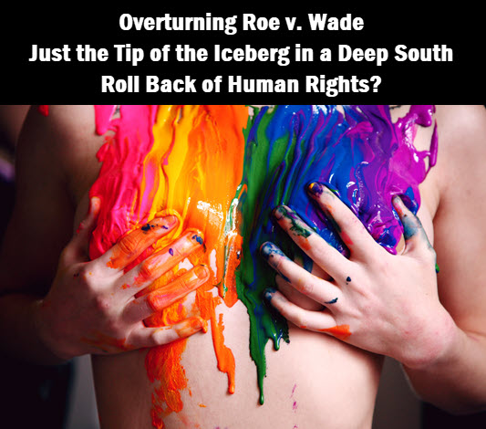 Photo of person painted in pride colors, with caption: Overturning Row v Wade will roll back the human rights of many in the deep south.