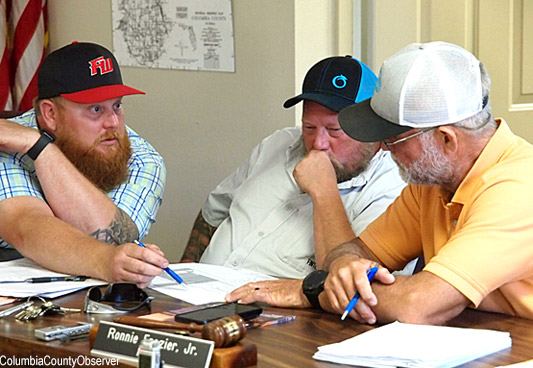 Councilmen Travis King and Jason Florence review the subdivision site plan with Mayor Ronnie Frazier.