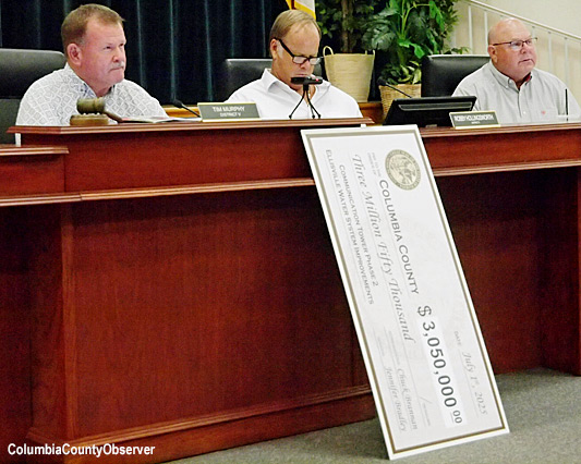 The $3M check rests on the floor